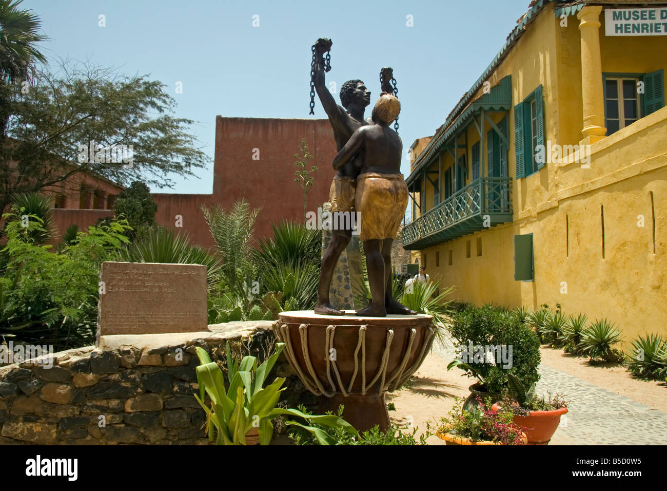 Isola di Goree Dakar in Senegal la libertà dalla schiavitù monumento con Maison des Esclaves o Casa degli Schiavi in background Foto Stock