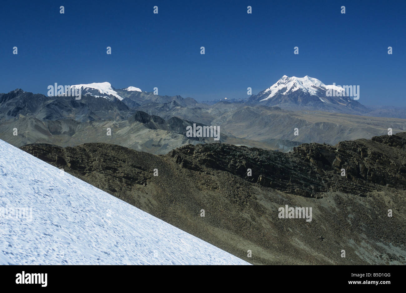 Mts Mururata (L) e Illimani (R) visto da Mt. Chacaltaya stazione ghiacciaio in primo piano, Cordillera Real, Bolivia Foto Stock