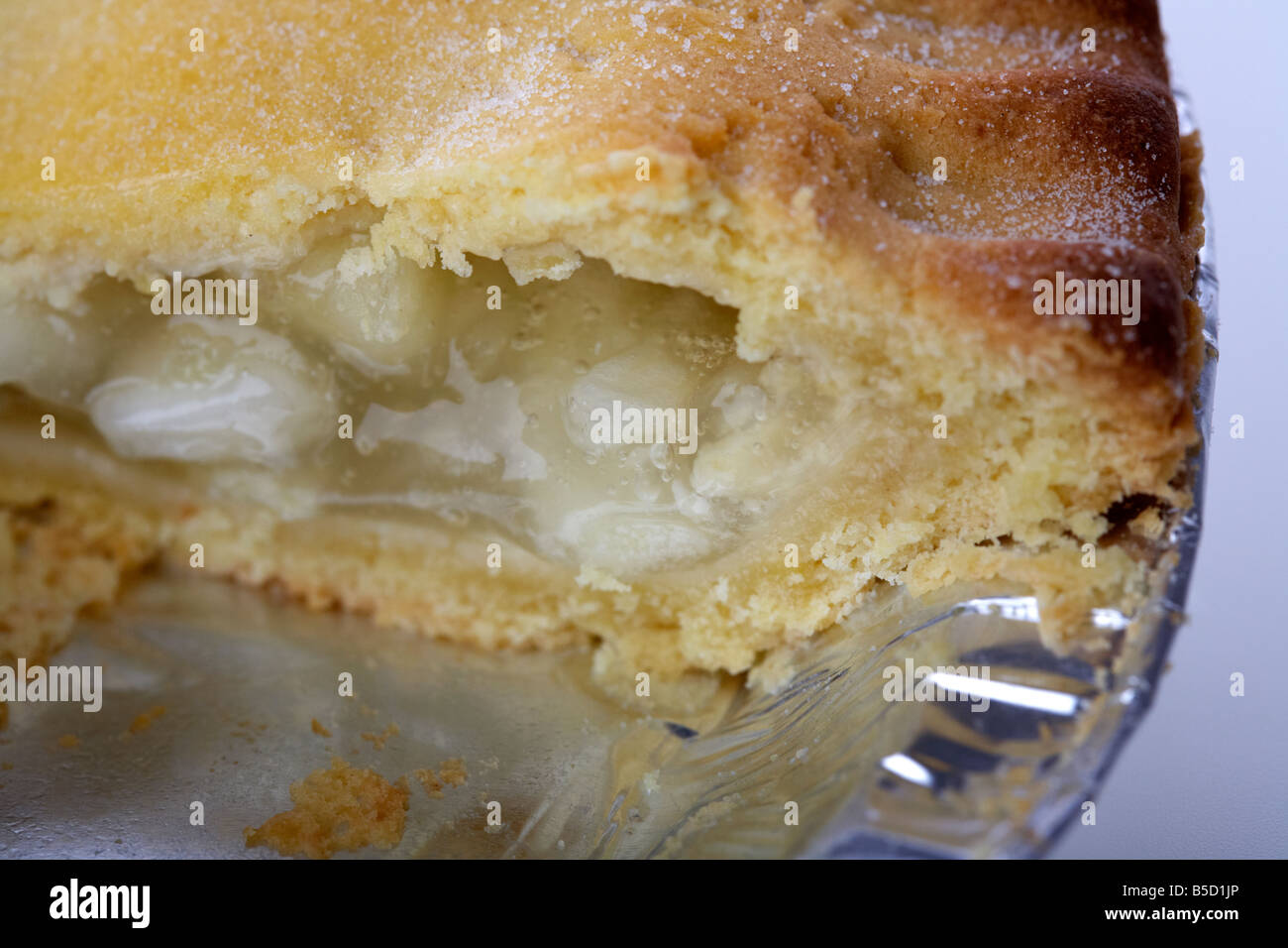 Close up di irish bramley apple pie torta in latta imballaggio piastra con fetta presa out Foto Stock