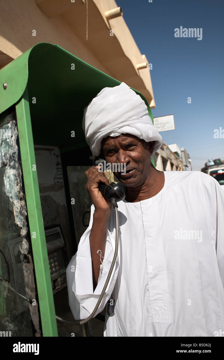 Uomo sudanese utilizzando un telefono nella città di Karima, Sudan, Africa Foto Stock