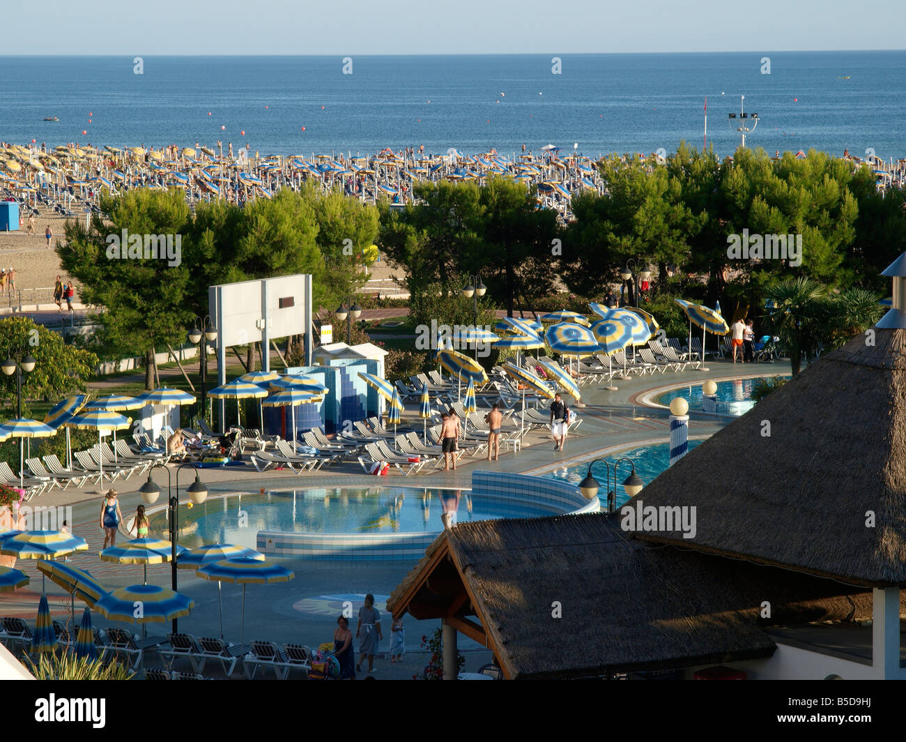 Località balneare spiaggia sabbiosa con un sacco di ombrelloni e hotel piscina, Bibione, mare adriatico, Nord Italia, Europa Foto Stock