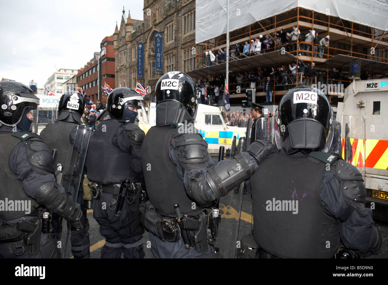 Linea di PSNI Servizio di Polizia dell'Irlanda del Nord squadra antisommossa funzionari di controllo modulo linea difensiva durante la protesta lealisti belfast Foto Stock
