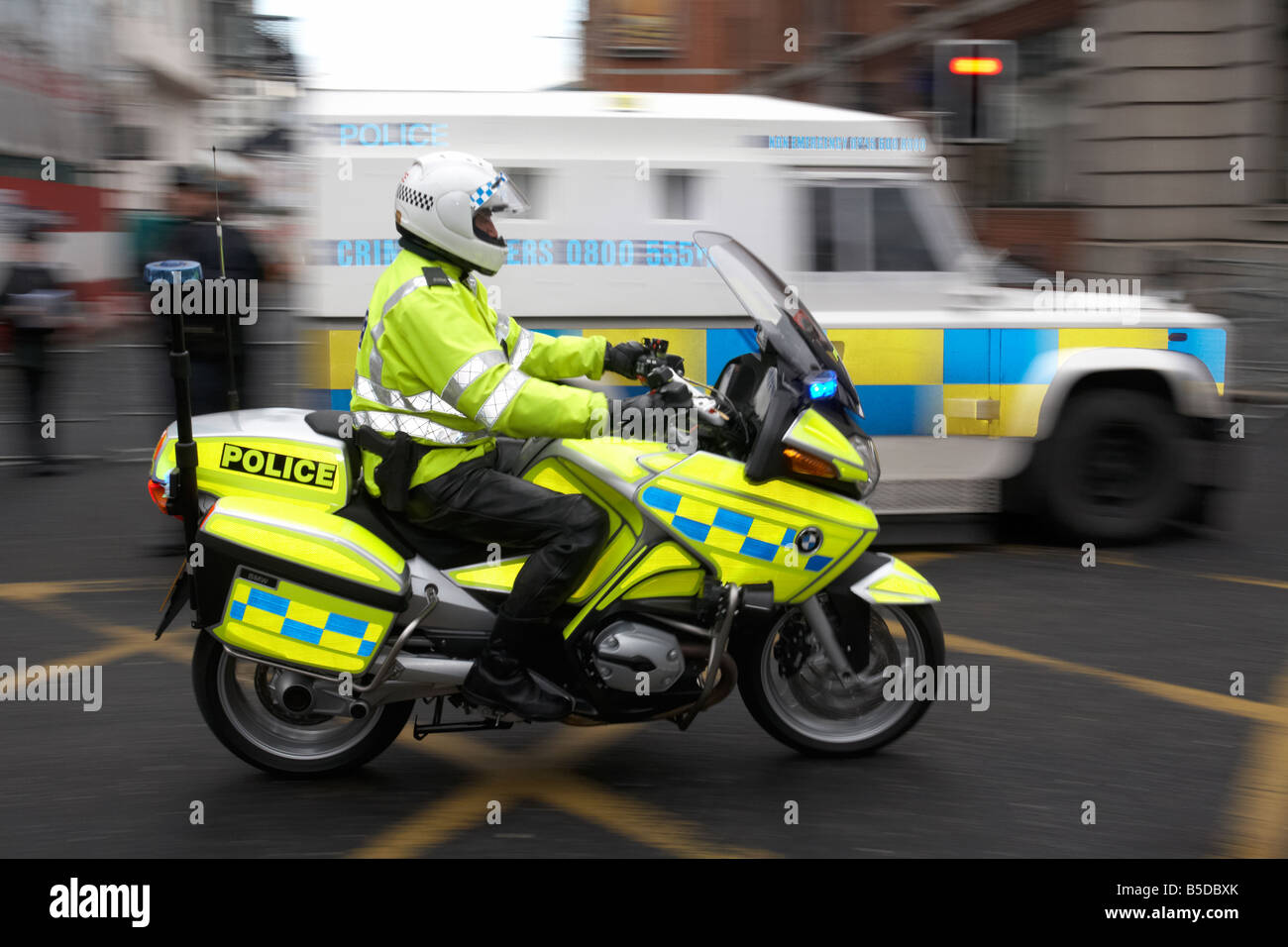 PSNI Servizio di Polizia dell'Irlanda del Nord motociclo officer accelerando attraverso belfast Foto Stock