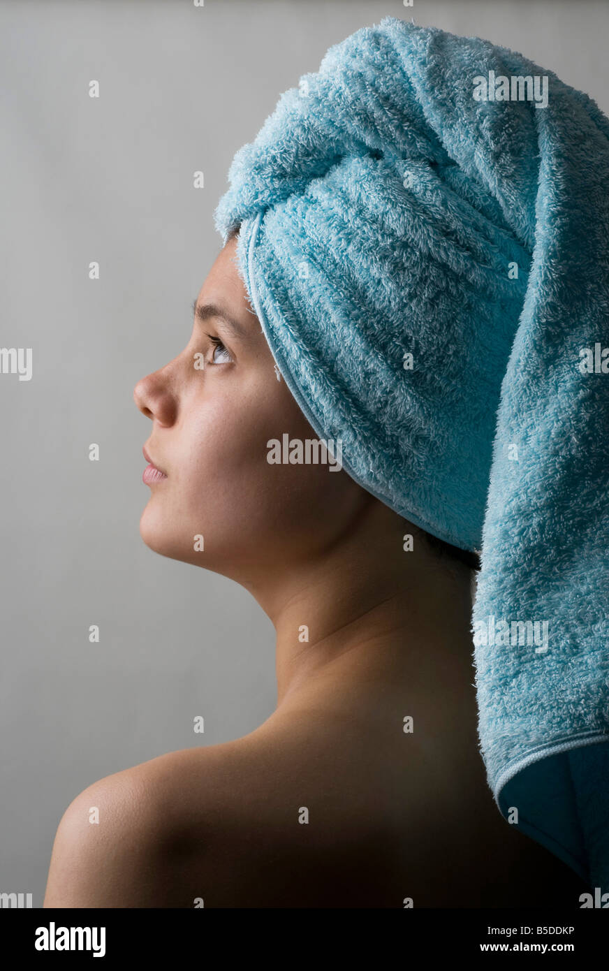 Piuttosto giovane adolescente con la testa avvolta in un asciugamano dopo il lavaggio i capelli Foto Stock