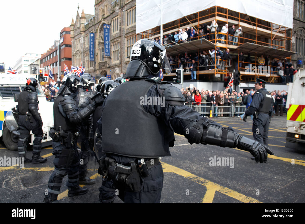 Linea di PSNI Servizio di Polizia dell'Irlanda del Nord squadra antisommossa funzionari di controllo modulo linea difensiva durante la protesta lealisti belfast Foto Stock