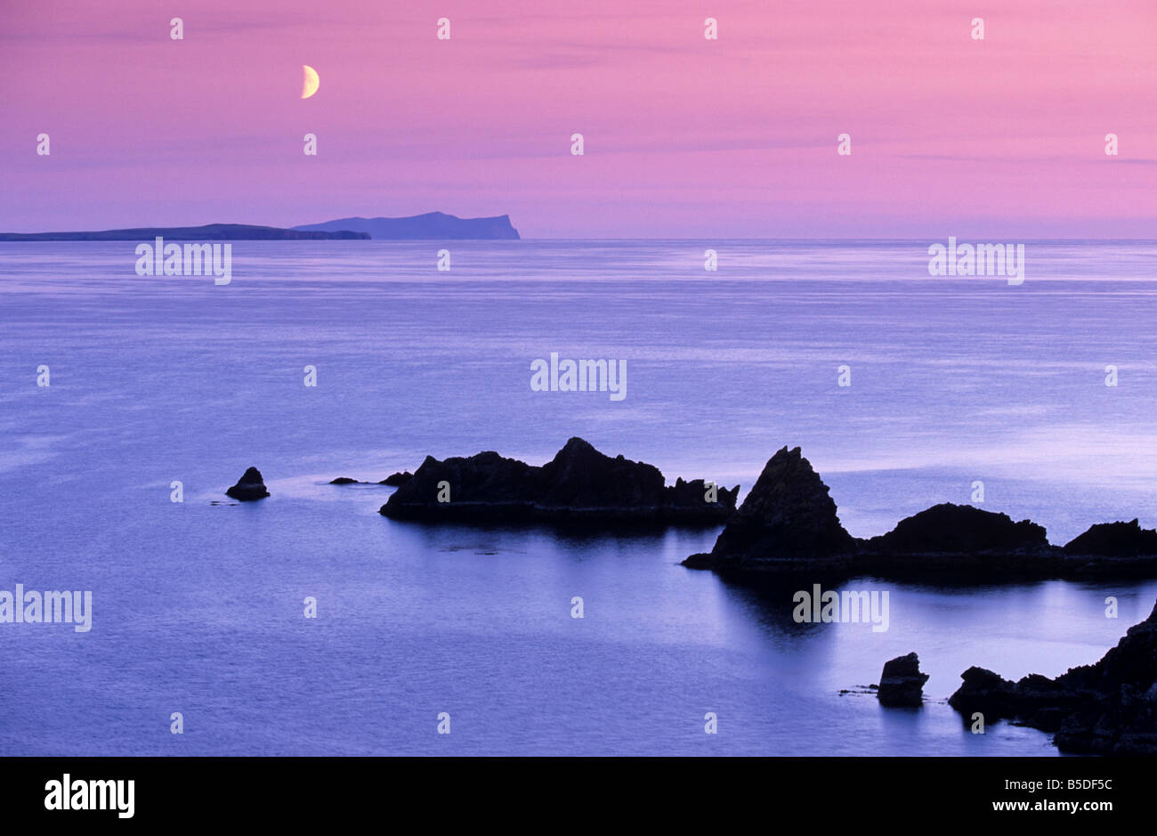 Tramonto sulla sabbia lo stoppino e la luna che sorge su Foula in distanza, Eshaness, Shetland Scozia, Europa Foto Stock