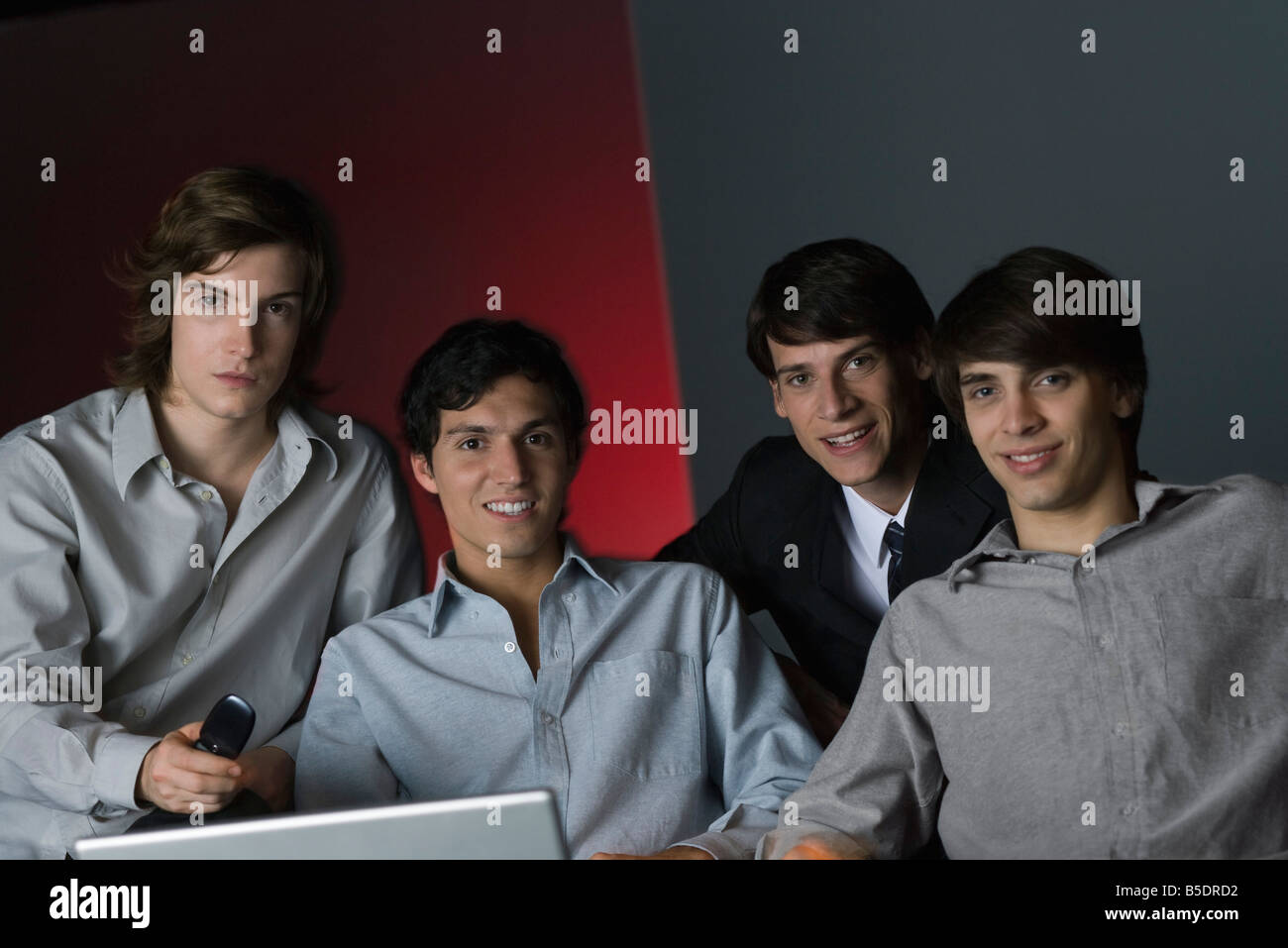 Professional uomini seduti fianco a fianco, sorridente in telecamera, ritratto Foto Stock
