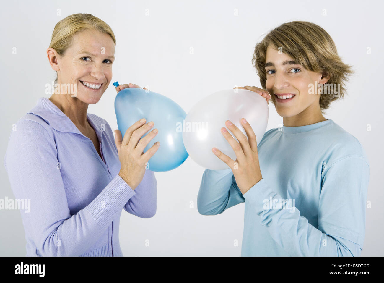 Madre e figlio teen gonfiare palloncini, sorridente in telecamera