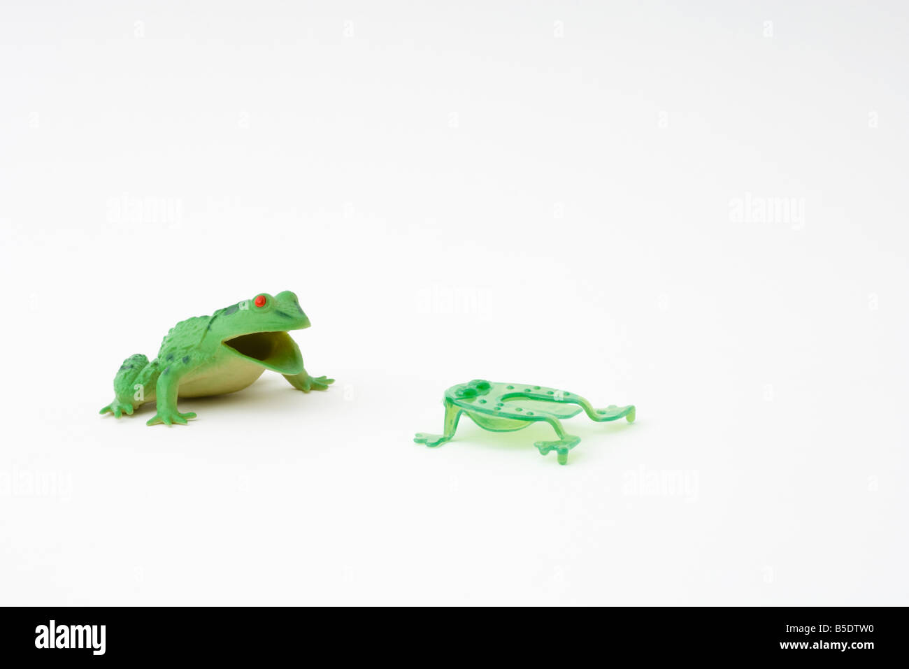 Rana rivolta verso il giocattolo più piccola rana in plastica Foto Stock