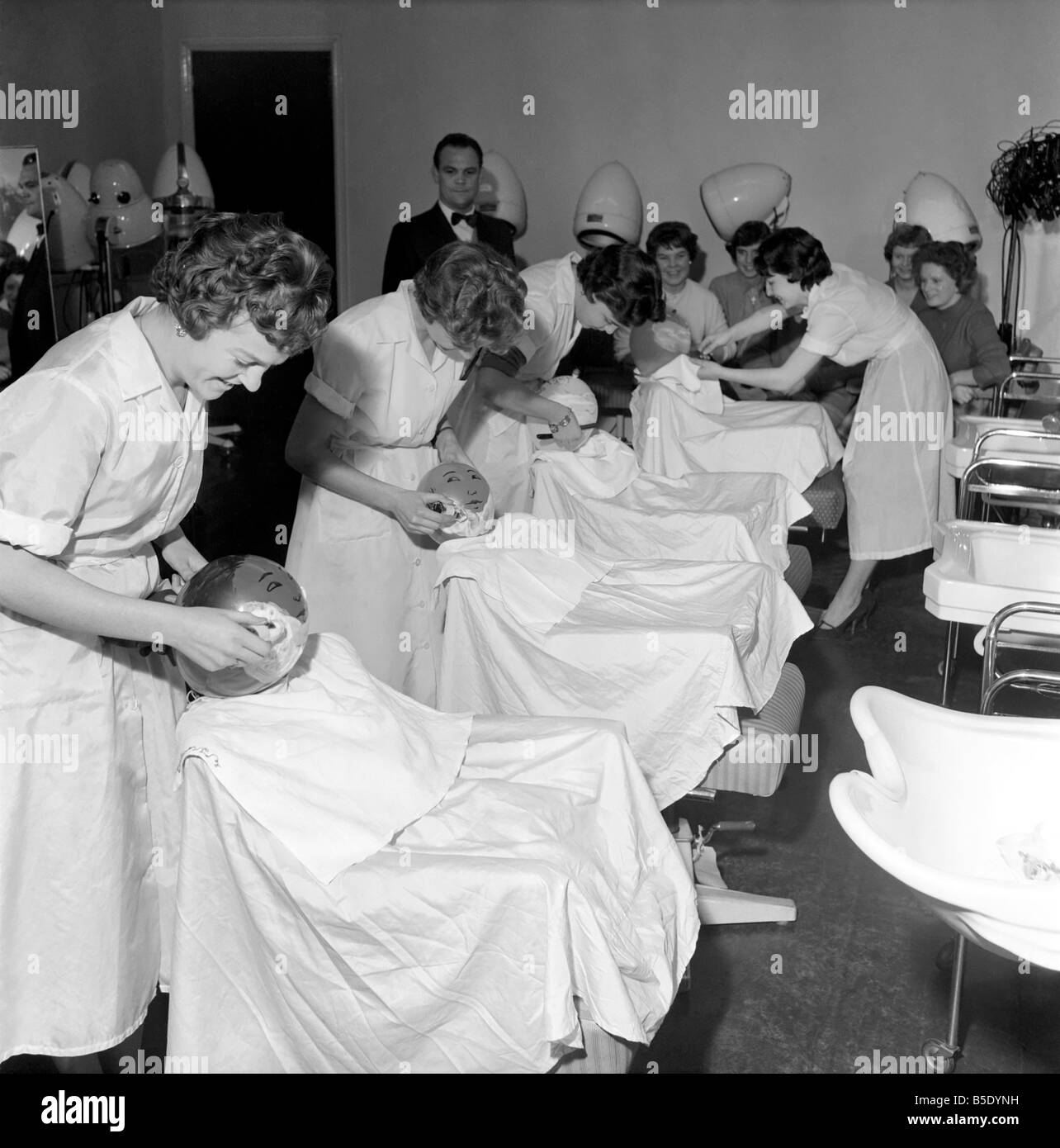 Donne barbieri formazione con gola tagliata rasoi, imparare a radersi utilizzando palloncini. Dicembre 1958 Foto Stock