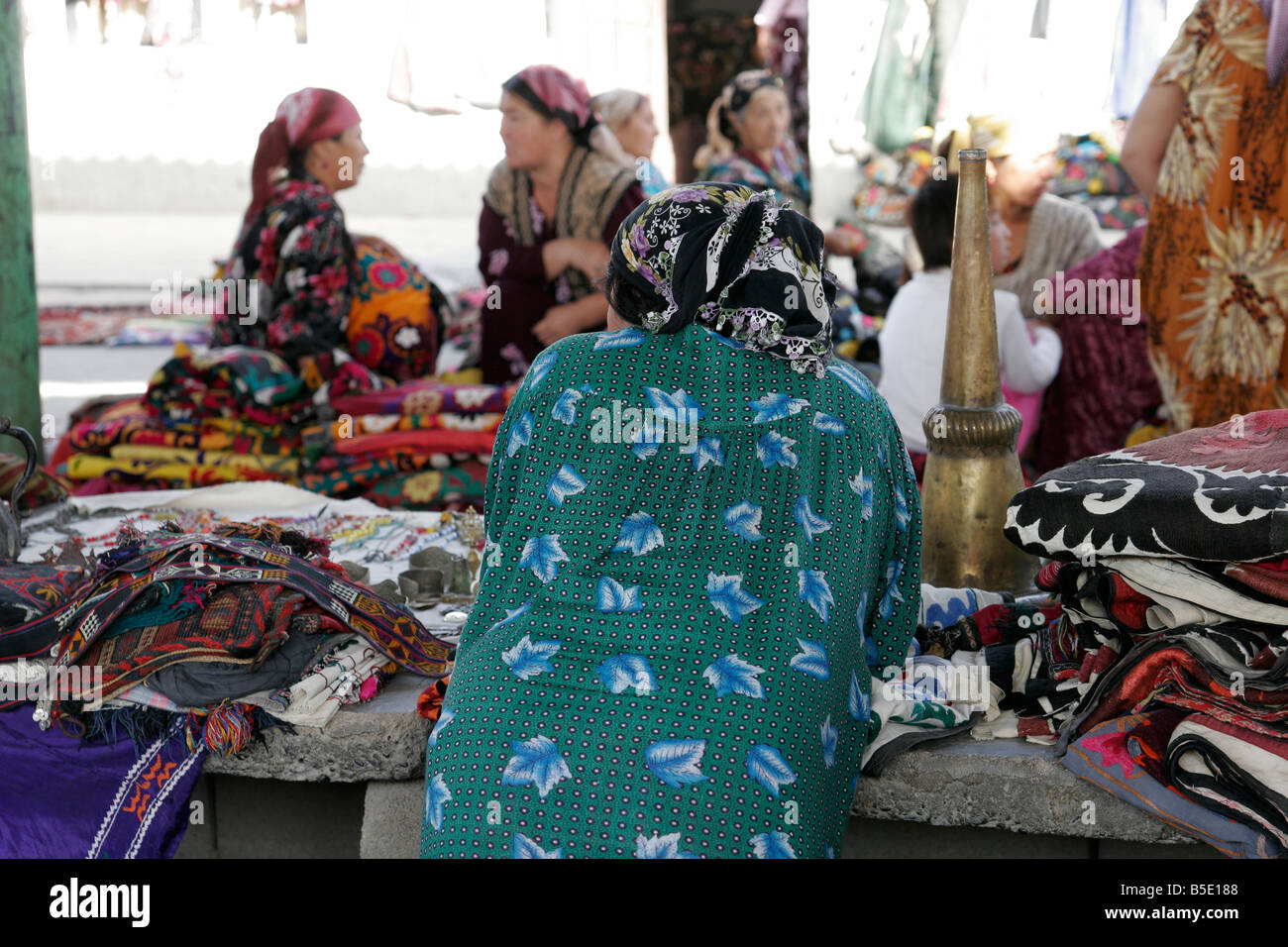 Uzbek donna vendita di tessili, mercato di domenica in Urgut, Uzbekistan in Asia centrale Foto Stock