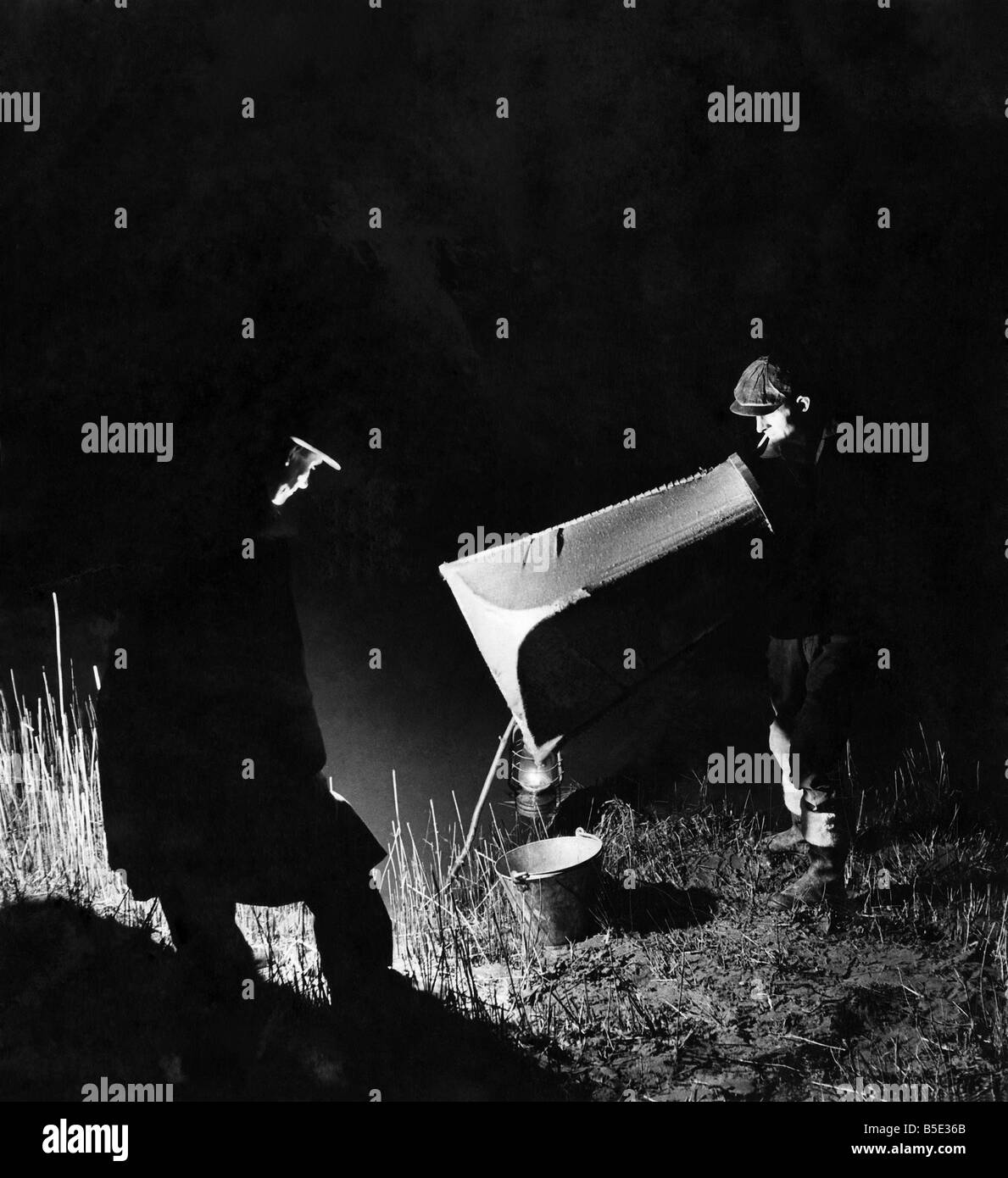 La pesca di anguille di notte. Le anguille sono attratti dalla luce riflessa della lampada, sciame rotonda come falene e può essere raccolto fuori in migliaia in corrispondenza di un tempo. ;Circa nel 1960 Foto Stock