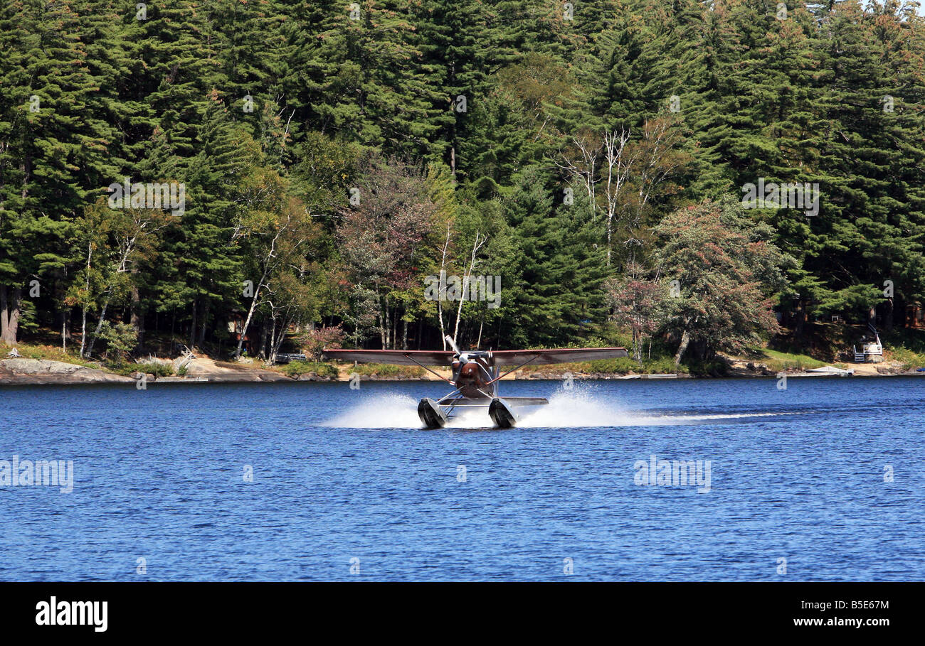 Un unico motore di float plane atterraggio sul lungo lago di New York. Foto Stock