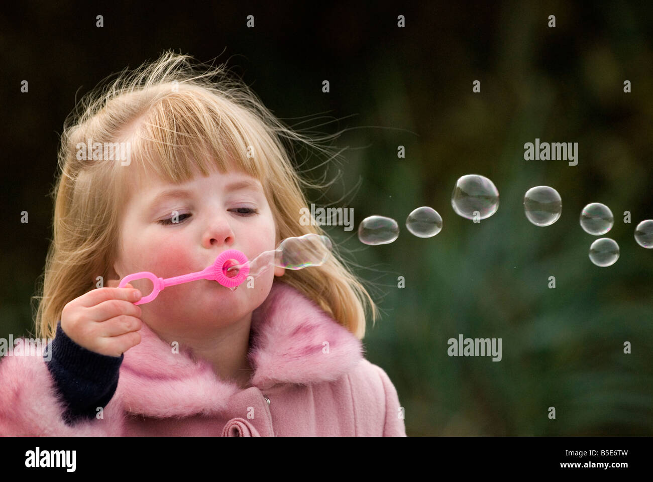 Ragazza a soffiare bolle al di fuori Foto Stock