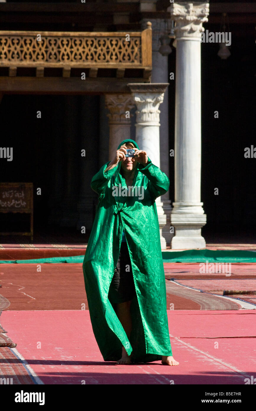 Donna turistica prendendo una foto all'interno della moschea di Al ibn al come nel Cairo Islamico Egitto Foto Stock