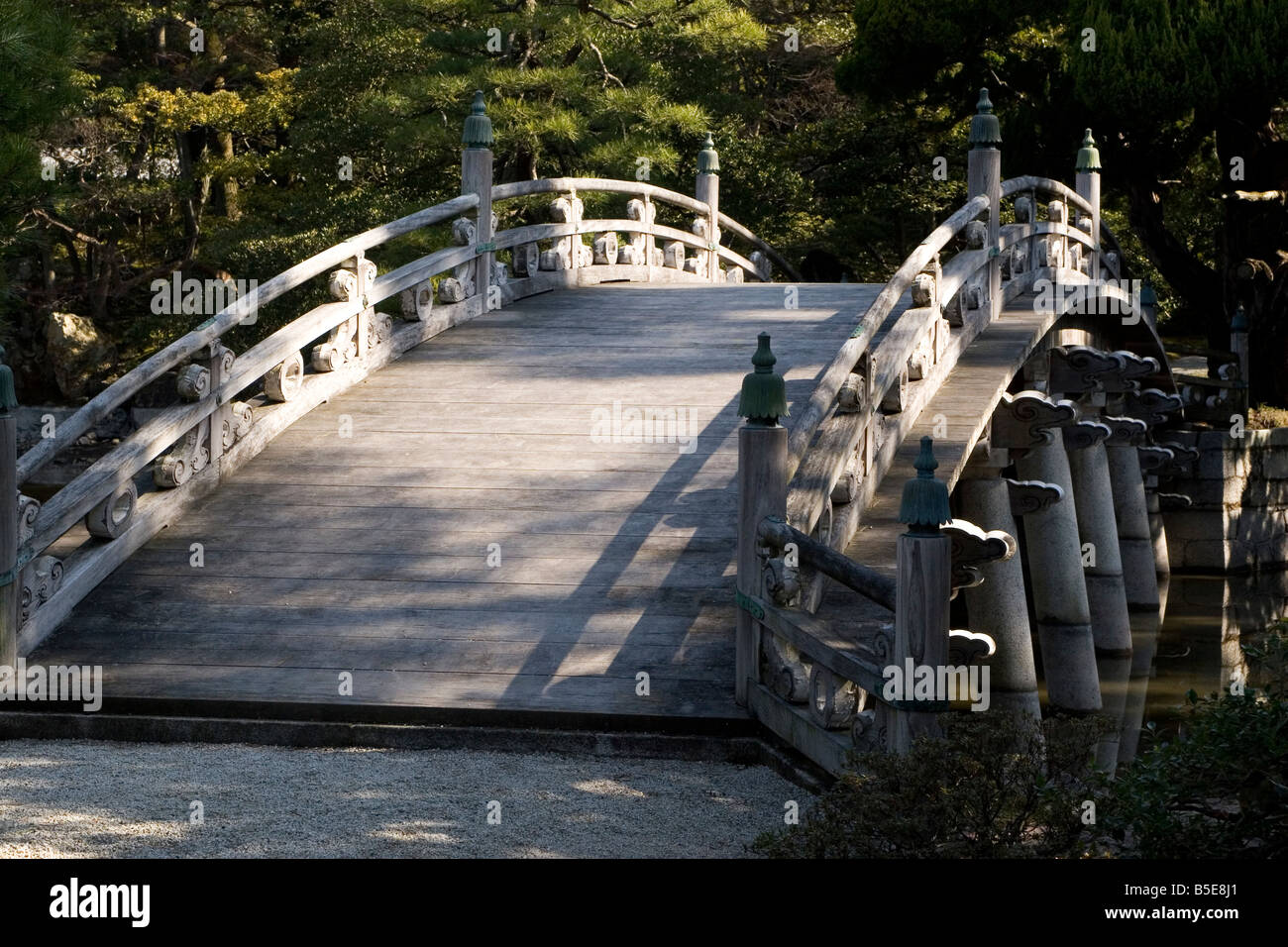 La forma arcuata Keyakibashi ponte di legno all'interno del Parco Imperiale intorno al Palazzo Imperiale di Kyoto in Giappone. Foto Stock