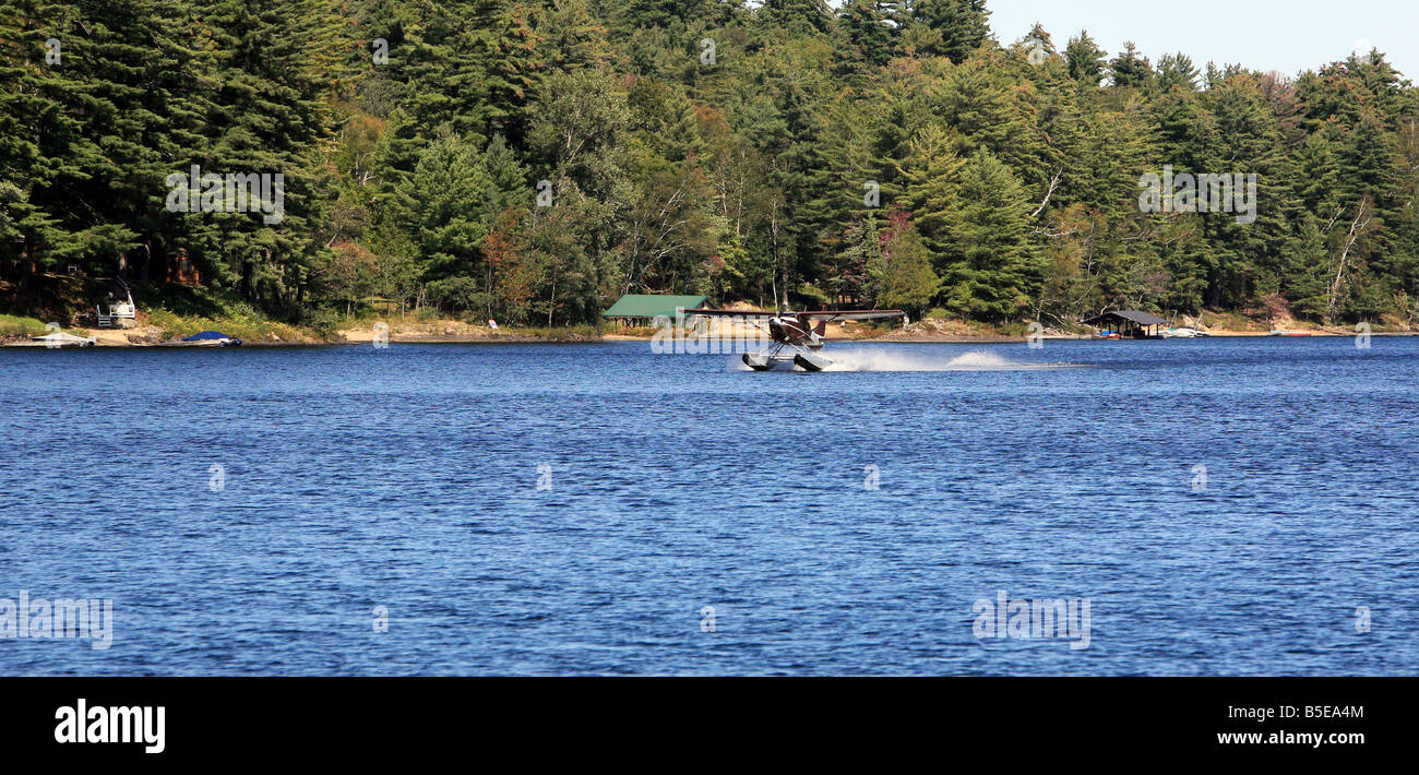 Un unico motore di float plane atterraggio sul lungo lago di New York. Foto Stock