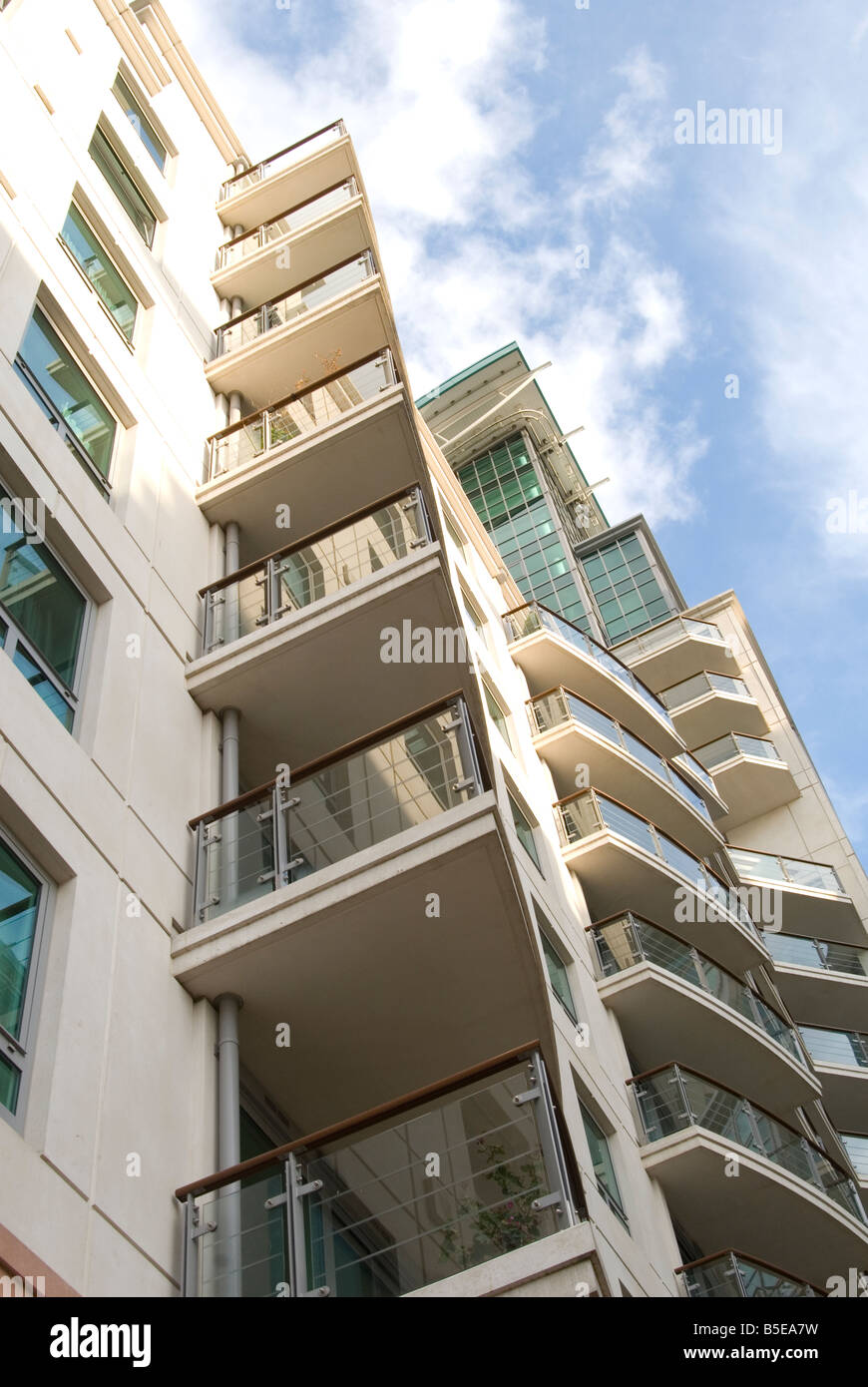 Un immagine guardando fino ad un moderno blocco di appartamenti a Londra con il blu del cielo di nuvole sopra Foto Stock