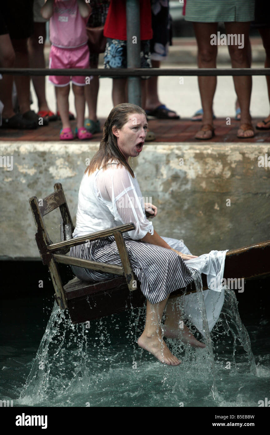 Rievocazione storica in St Georges, Bermuda, mostra una donna essendo si chinò in porto per essere uno scandalo. Foto Stock