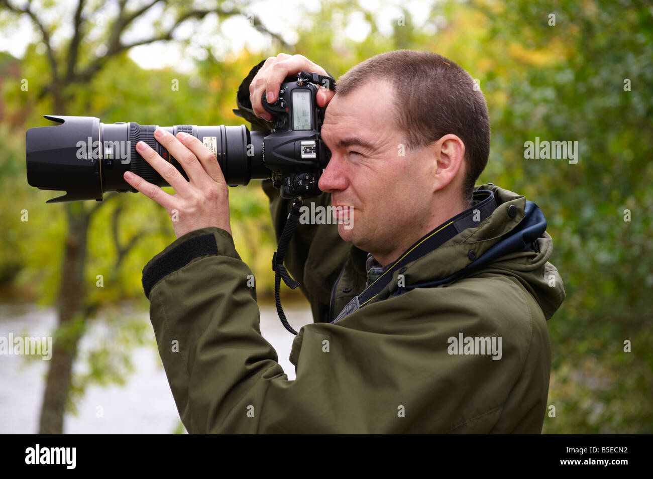Fotografo utilizzando un D300 con Nikon 70-200mm VR lente fuori dal fiume di Scozia UK Foto Stock