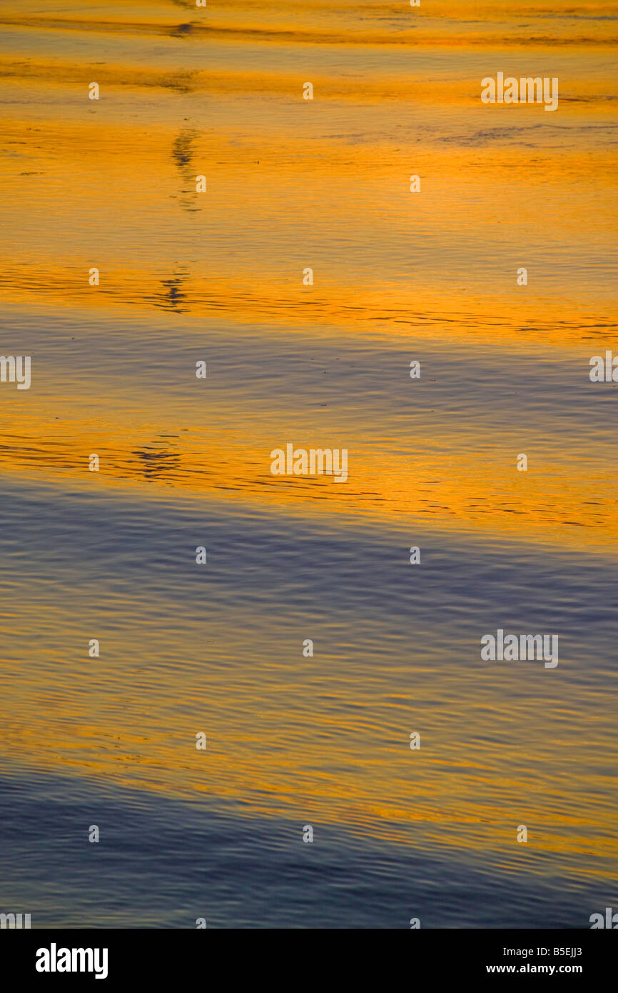 Onde sull'acqua al tramonto Foto Stock