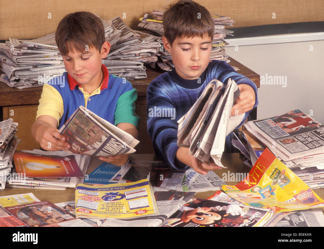Due giovani ragazzi il riciclaggio della carta a scuola Foto Stock