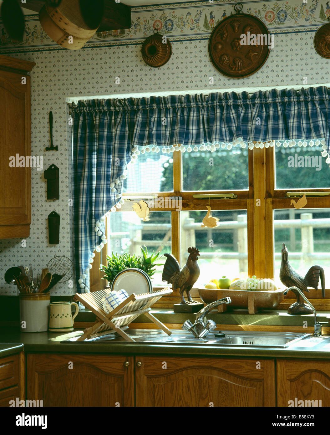 Dipinte a mano di confine controllato sulla parete sopra voile tenda da  finestra bianca sopra il lavandino in giallo cucina cottage Foto stock -  Alamy