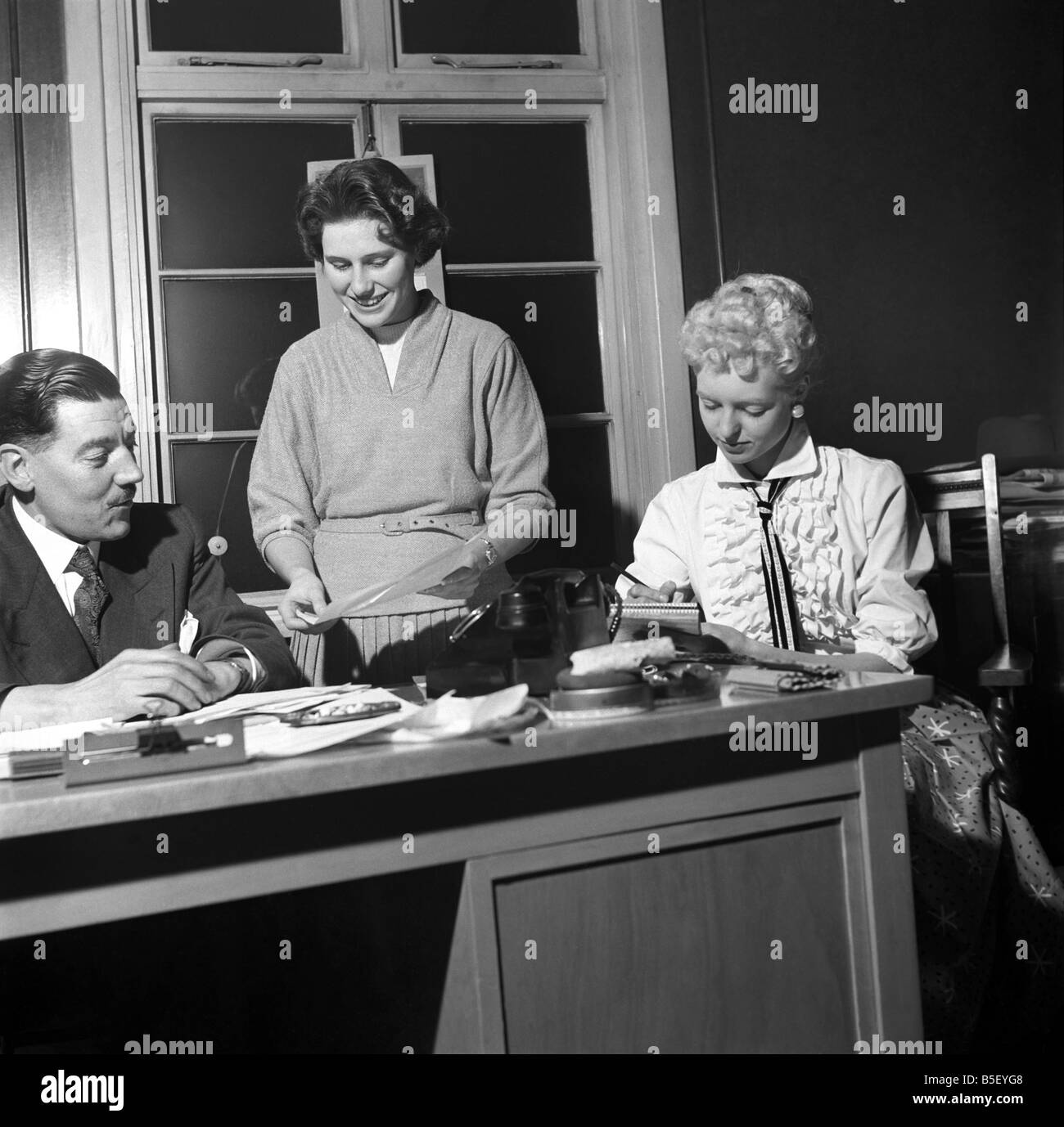 Ufficio generale scena: Segretario prendendo appunti e rispondere al telefono in un ufficio di Birmingham. Un573-001 Foto Stock