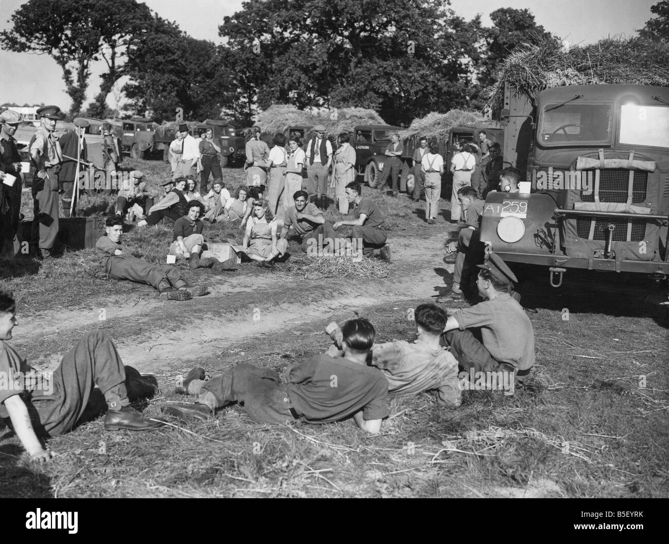 Soldati e nell esercito ragazze prendere un periodo di riposo per una tazza di tè durante un raccolto di East Anglia &#13;&#10;settembre 1942 Foto Stock