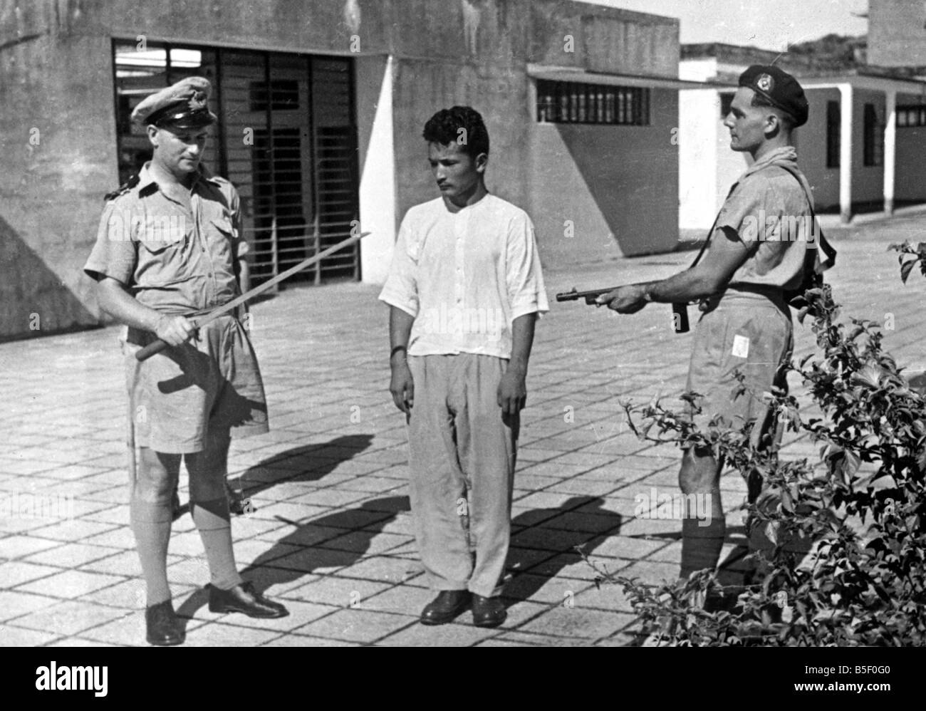 Giapponese i criminali di guerra e British collaboratori incarcerato a Hong Kong. OPS tenente R. Leigh-Potter esamina la spada precedentemente utilizzato da un criminale di guerra sergente Kenichi Matsuda.;12 Novembre 1945 Foto Stock