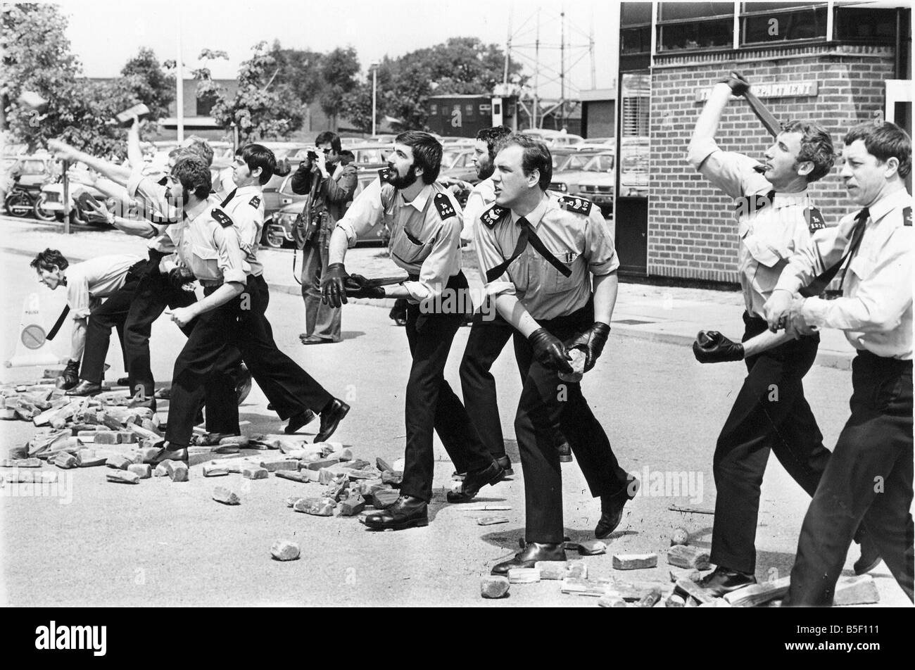 Formazione di base 1978 stile cadetti di polizia impara a trattare con una situazione di tumulto che prendere rivoltosi lasciate volare con mattoni e macerie Foto Stock