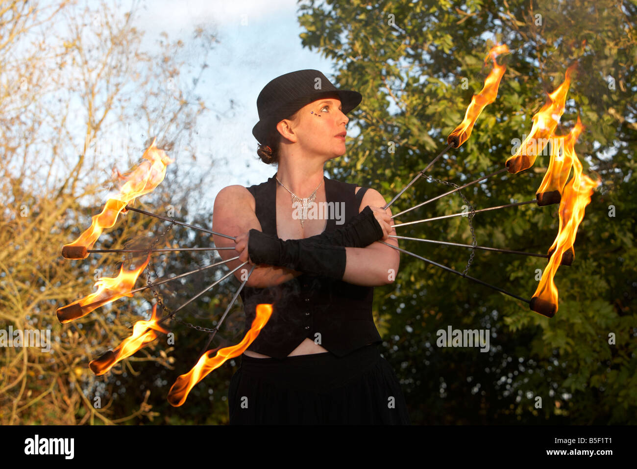 Femmina firepoise fire performance di danza artista indossando hat azienda ventilatori antincendio Foto Stock