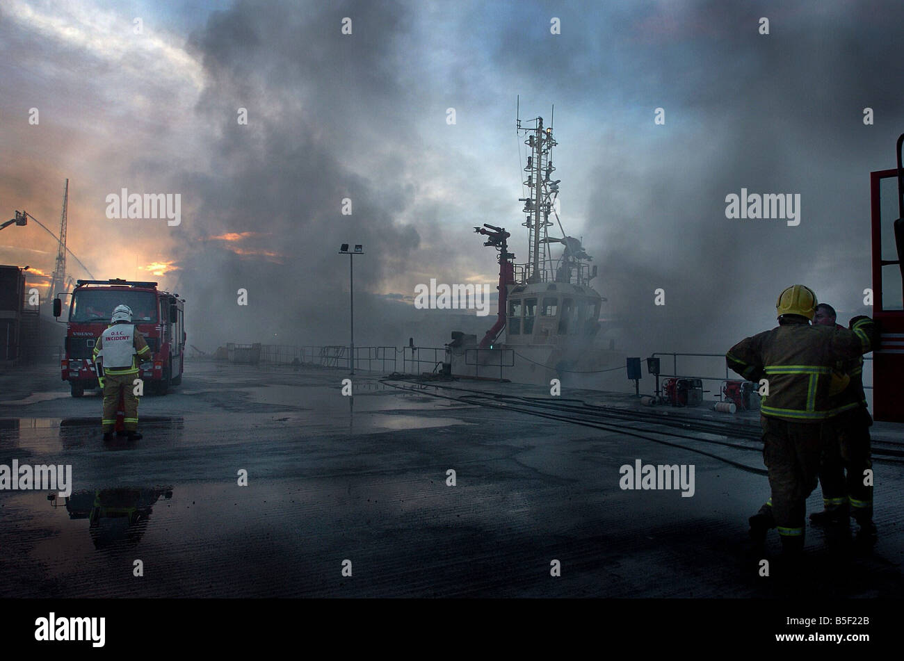 Flutti di fumo da sotto un molo di cemento dal fiume Tyne nel Hebburn in background è un rimorchiatore che doveva essere portato da Middlesbrough per contribuire ad affrontare il blaze Foto Stock