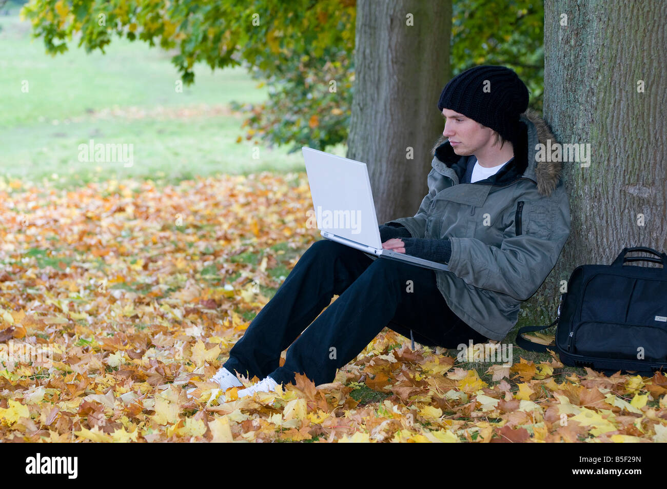 Giovane maschio studente utilizzando il computer portatile Foto Stock