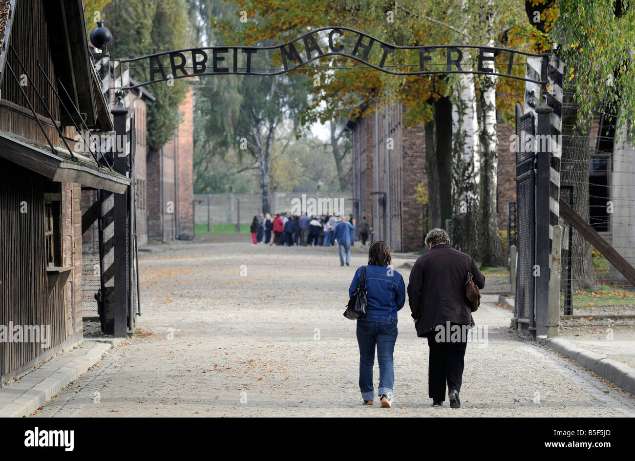 La gente camminare attraverso l'ingresso di sterminio di Auschwitz camp. Foto Stock