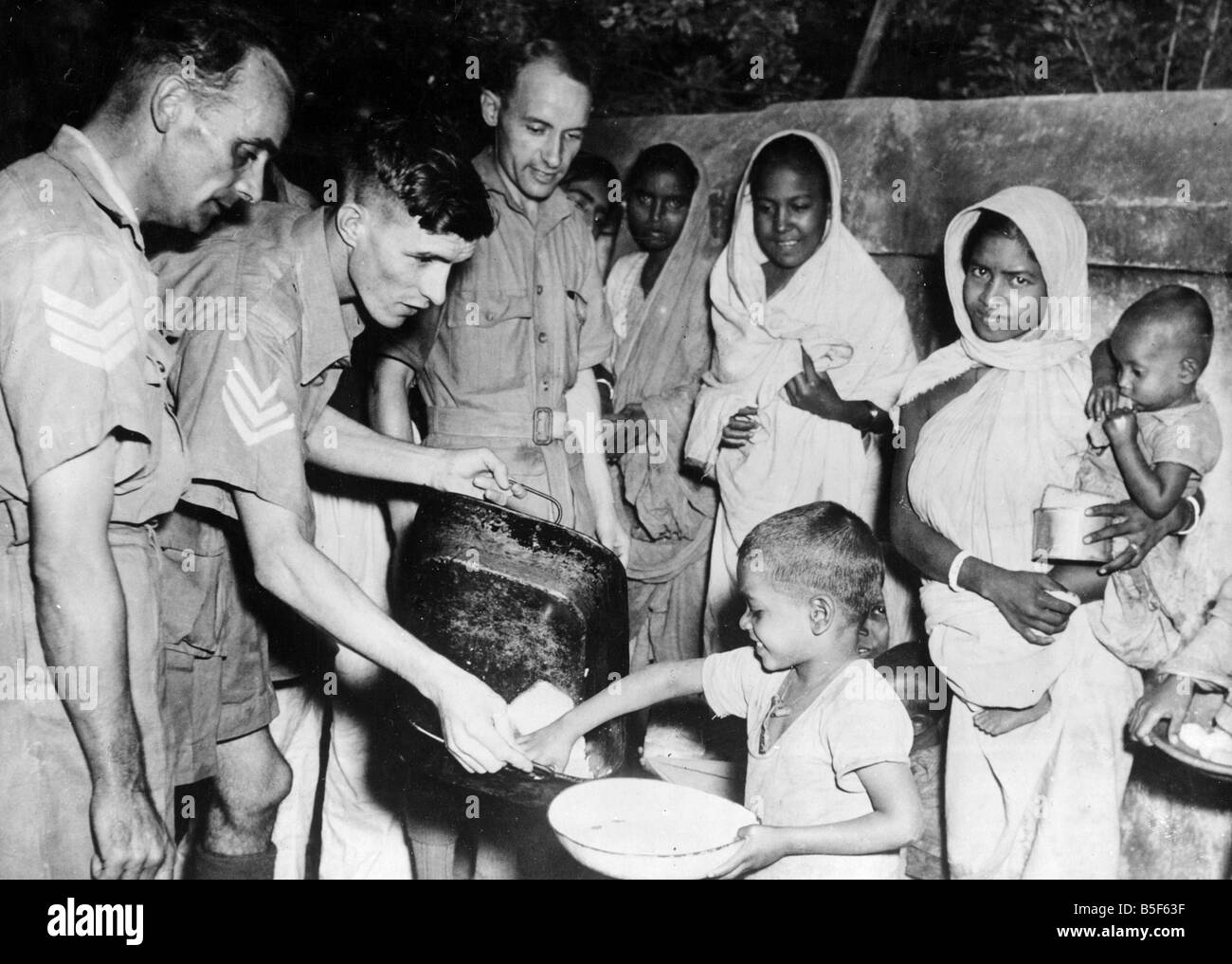 Gli uomini della Royal Air Force di alimentazione bambini locale in tre Indian aree di carestia in corrispondenza di una stazione di raf nel Bengala, India durante la Seconda Guerra Mondiale;Dicembre 1943 Foto Stock