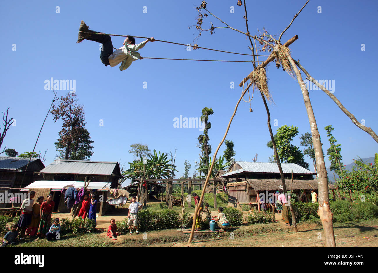 Ragazzo su una oscillazione in un villaggio in Nepal Foto Stock