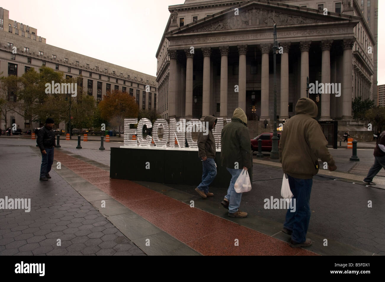 Una scultura di ghiaccio della parola economia intitolata Main Street Meltdown fonde in Foley Square a New York Foto Stock