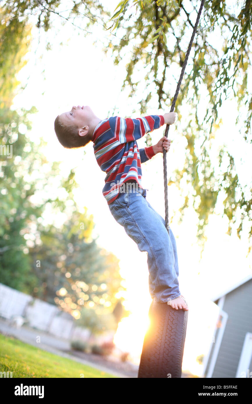 Quattro anni di vecchio ragazzo giocando sulla rotazione dei pneumatici Foto Stock