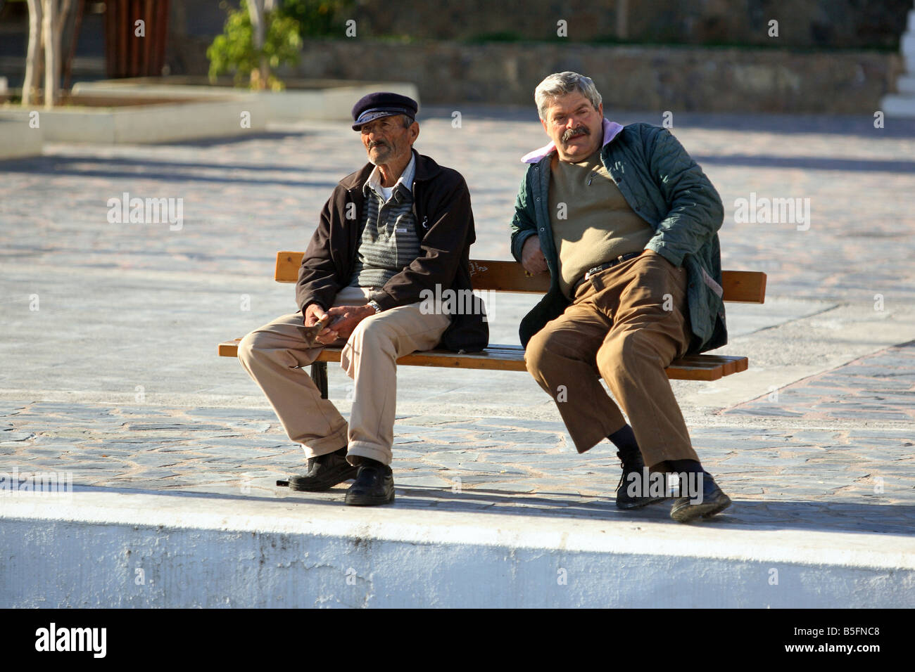 Due uomini seduti su un banco di lavoro e di riposo, Agios Nikolaos, Grecia Foto Stock