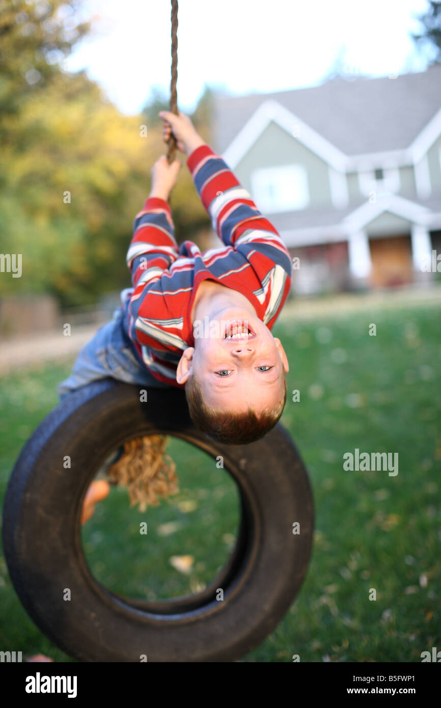 Quattro anni di vecchio ragazzo giocando sulla rotazione dei pneumatici Foto Stock