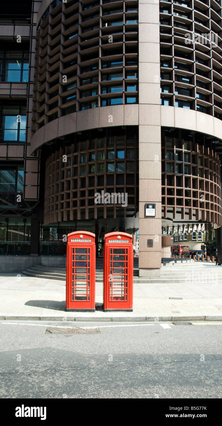 2 telefono rosso scatole al di fuori di una banca della città Foto Stock