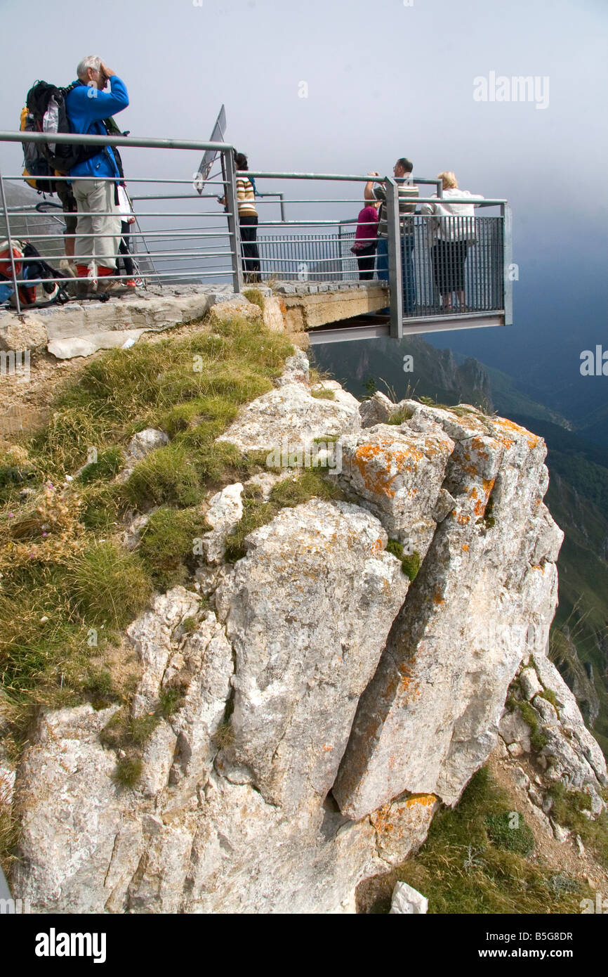 Visitatori stand su una piattaforma che si affaccia sul Picos de Europa a Fuente De Liebana Cantabria Spagna nord-occidentale Foto Stock
