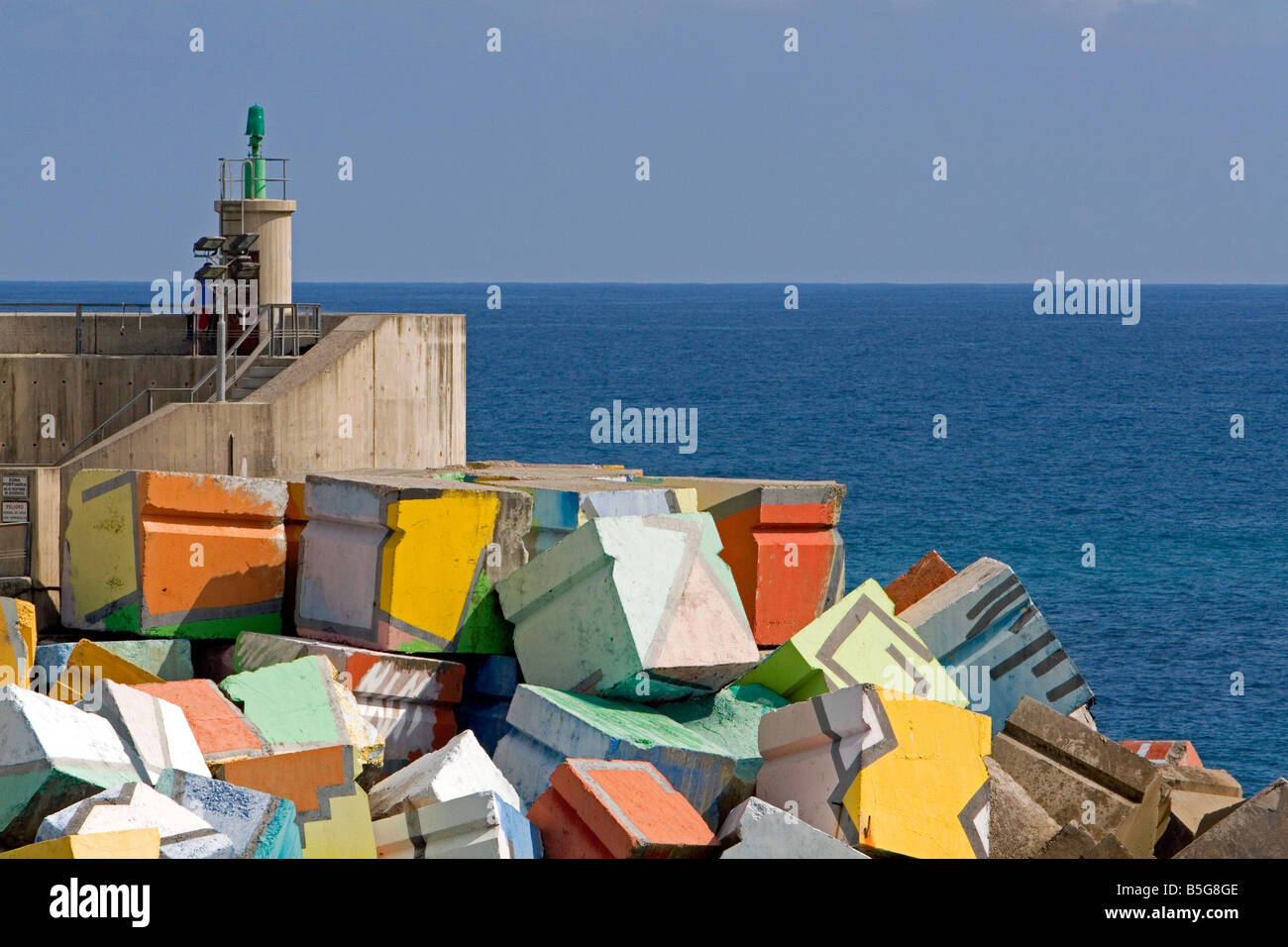 Dipinto di blocchi di cemento nel porto a Llanes Asturias Spagna Foto Stock