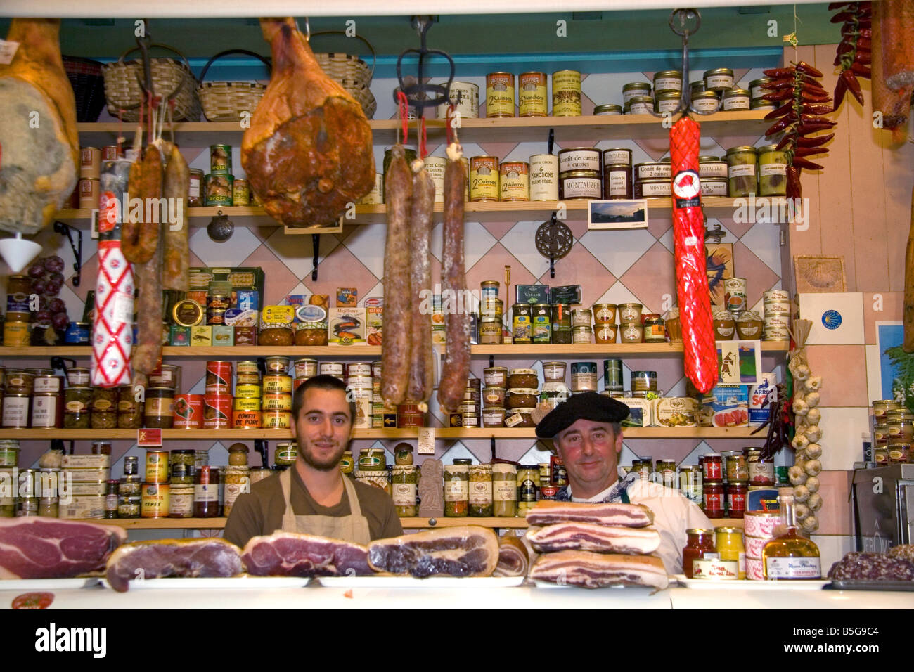 Basco francese uomini al lavoro in un negozio di formaggi e carni nella città di Saint Jean de Luz a sud-ovest della Francia Foto Stock