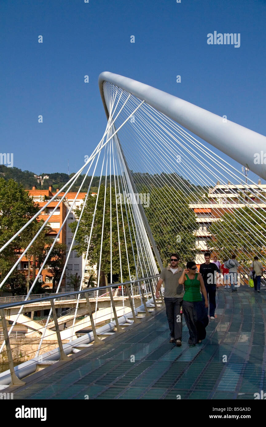 La gente camminare attraverso la passerella Zubizuri spanning del fiume Nervion di Bilbao Biscay Paesi baschi Spagna settentrionale Foto Stock