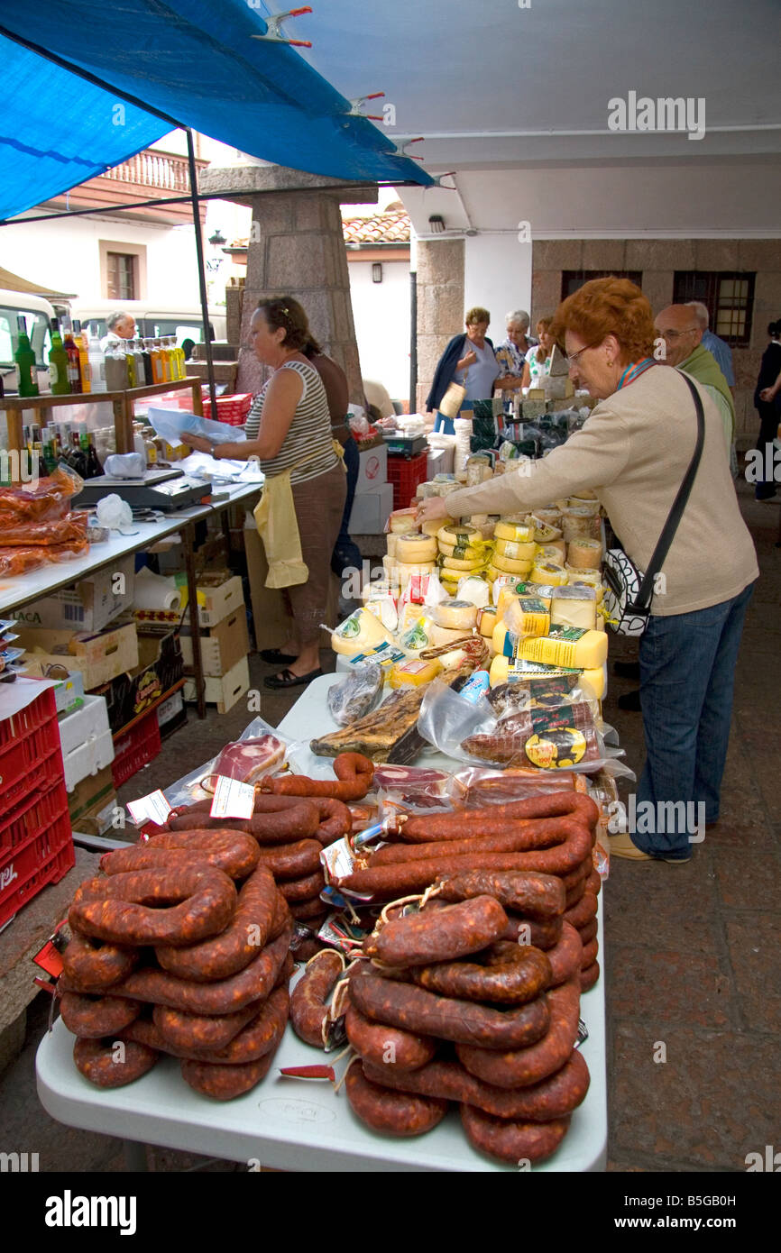 Venditore la vendita di formaggio e salumi presso un mercato all'aperto nella città di Cangas de Onis Asturias Spagna settentrionale Foto Stock