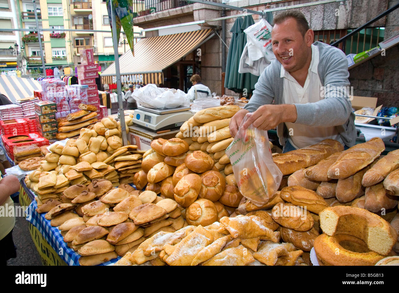 Venditore a vendere pane e prodotti da forno in un mercato all'aperto nella città di Cangas de Onis Asturias Spagna settentrionale Foto Stock
