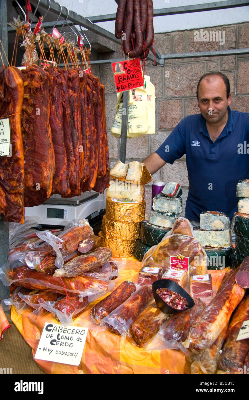 Venditore a vendere salumi e formaggi presso un mercato all'aperto nella città di Cangas de Onis Asturias Spagna settentrionale Foto Stock