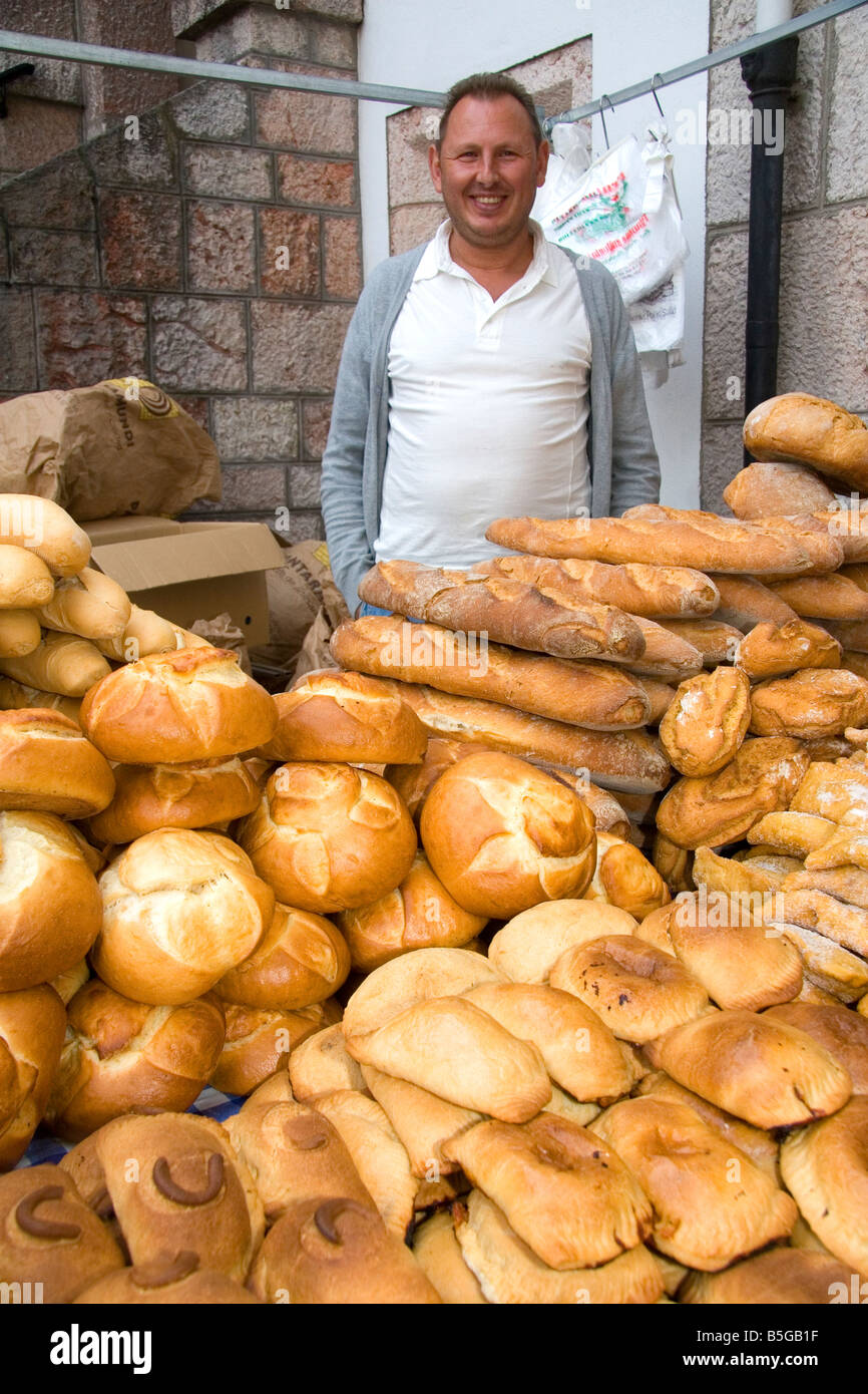 Venditore a vendere pane e prodotti da forno in un mercato all'aperto nella città di Cangas de Onis Asturias Spagna settentrionale Foto Stock
